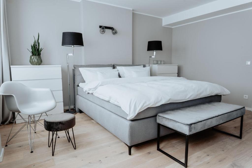明斯特2-Zimmer City Apartment 57m² mit King Size Bett und Küche的一间卧室配有一张大床和一把椅子