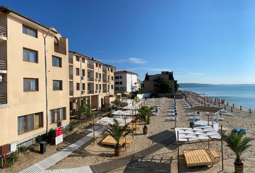 克兰内沃Palma Beach Hotel的海滩上设有躺椅和建筑,大海中