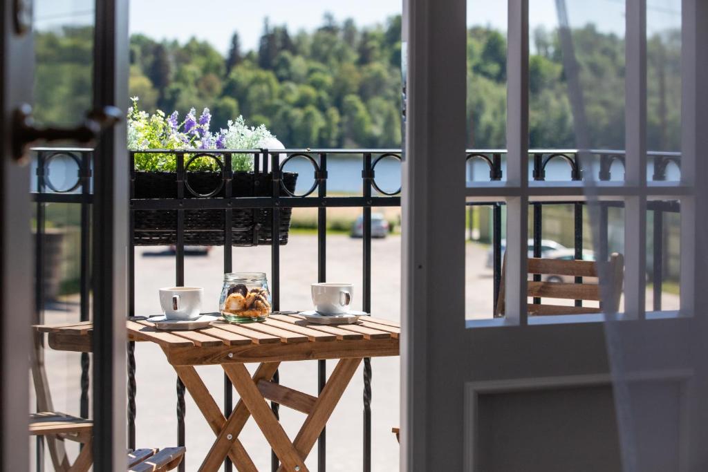 维尔扬迪亚撒旅馆的阳台上的桌子,上面放着两杯和鲜花