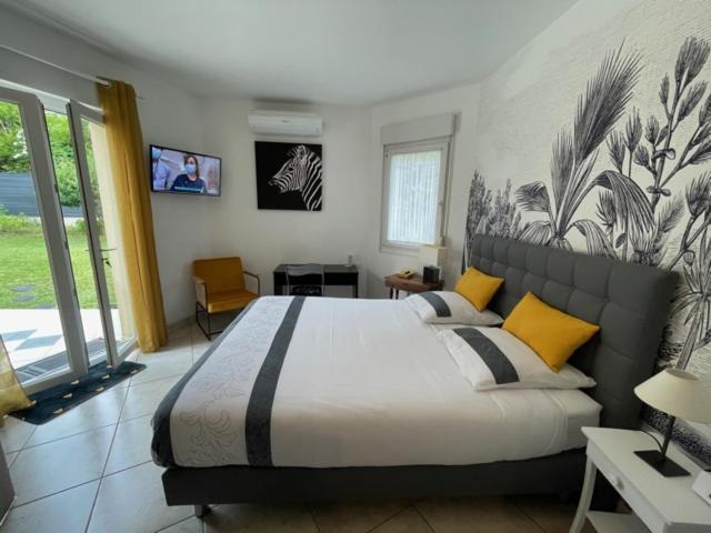南希STUDIO BEAUREGARD - TERRASSE et JARDIN的一间卧室配有一张大床,提供黄色和黑色的枕头