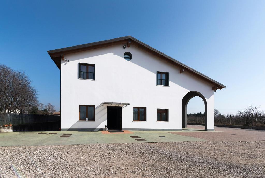 维罗纳Agriturismo Le Grazie的一座白色的大建筑,有黑色的门道