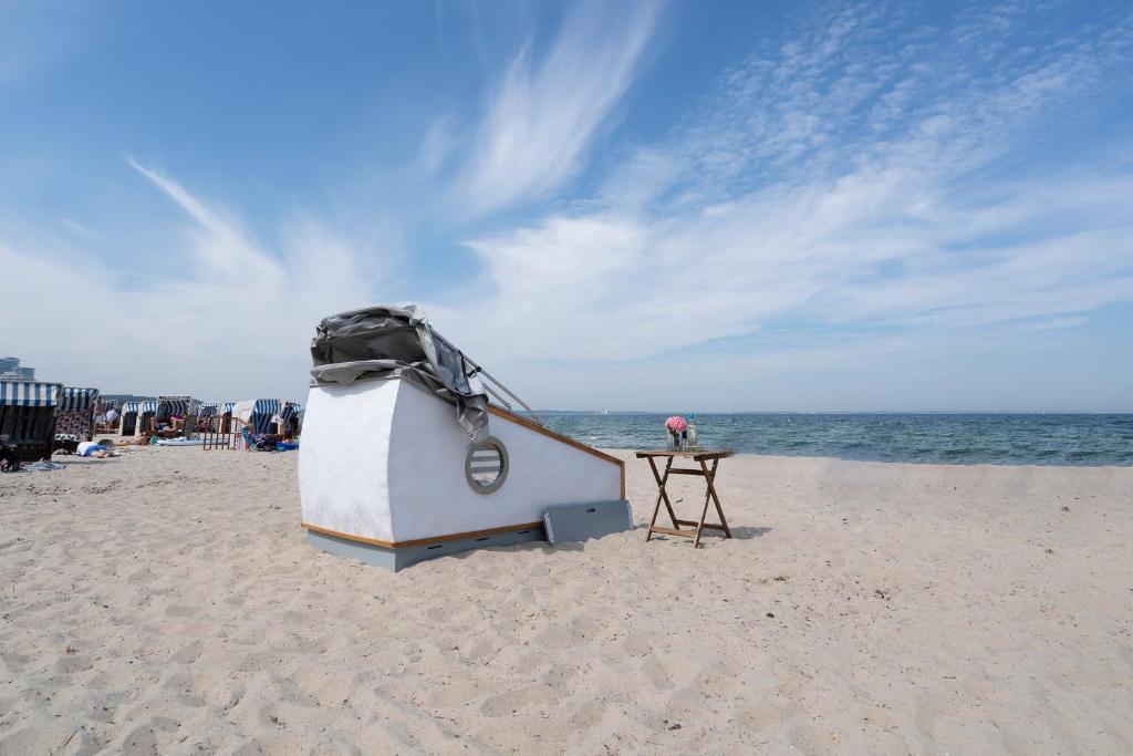 蒂门多弗施特兰德Schlafstrandkorb Nr. 4的海滩上的小船,带桌子