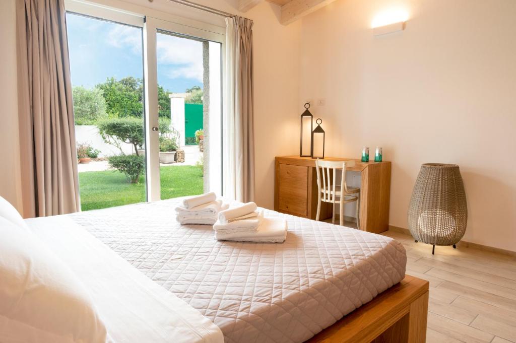奥尔比亚Villa Summer Luxury Apartment的一间卧室配有一张大床和毛巾