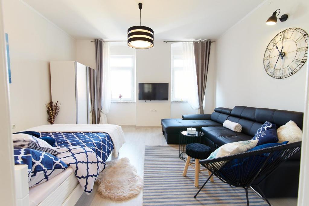 里耶卡Studio Apartman Manuela的客厅配有蓝色真皮沙发和时钟