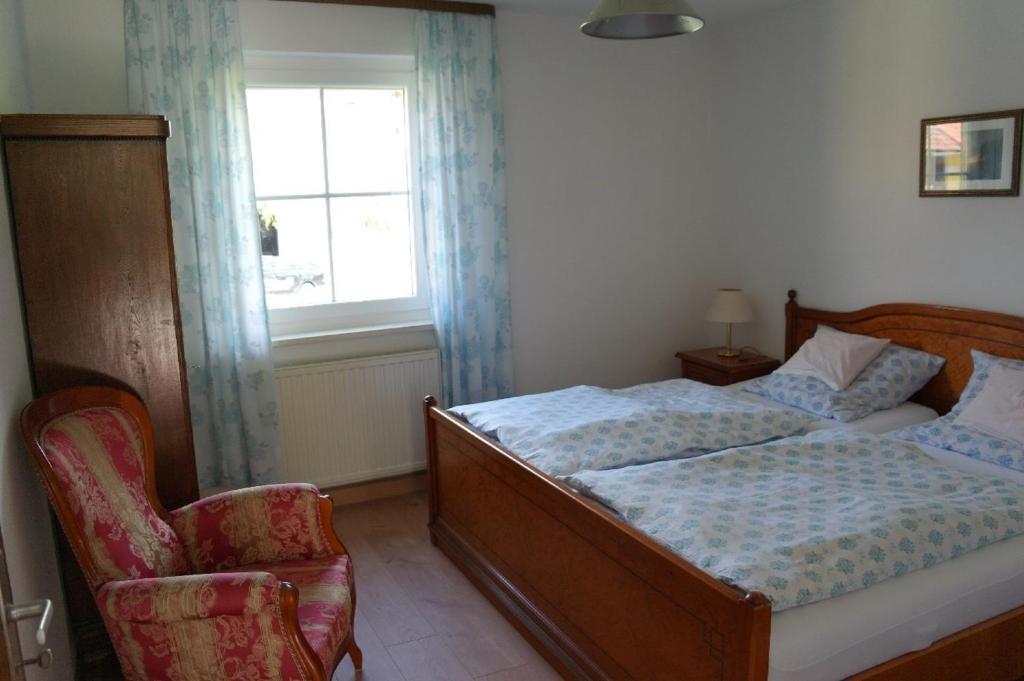 RingelaiFerienhaus Bayerwald的卧室配有床、椅子和窗户。