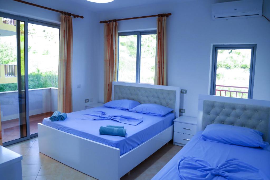 都拉斯Vila Namiku的一间蓝色卧室,配有两张床和窗户