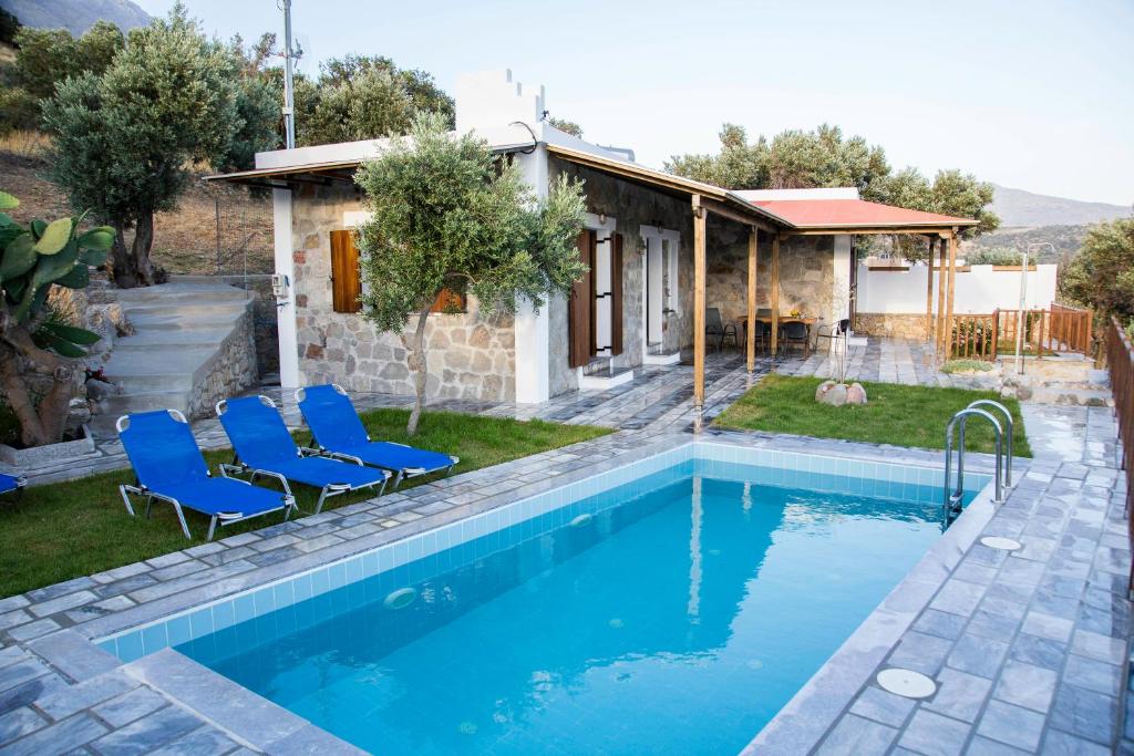 特里欧皮特拉Villa Aloni in Triopetra的一个带蓝色椅子的游泳池