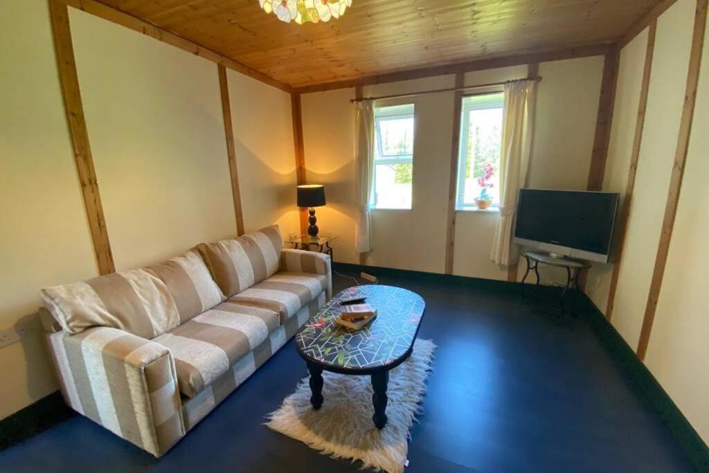 斯温福德The Cosy Cabin的客厅配有沙发和桌子