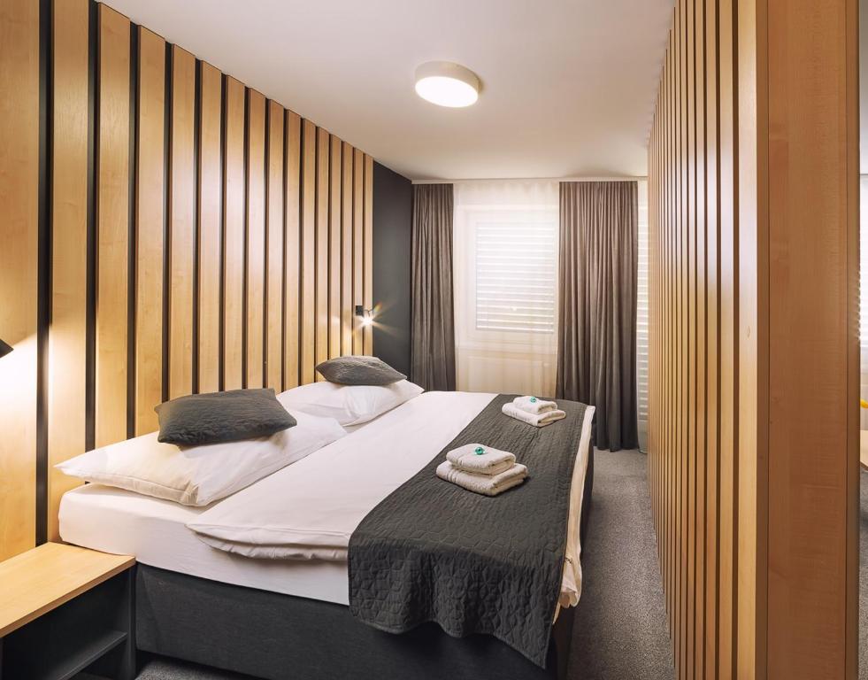 利普托斯基米库拉斯TIMEOUT City Hotel的一间卧室配有一张带白色床单的大床