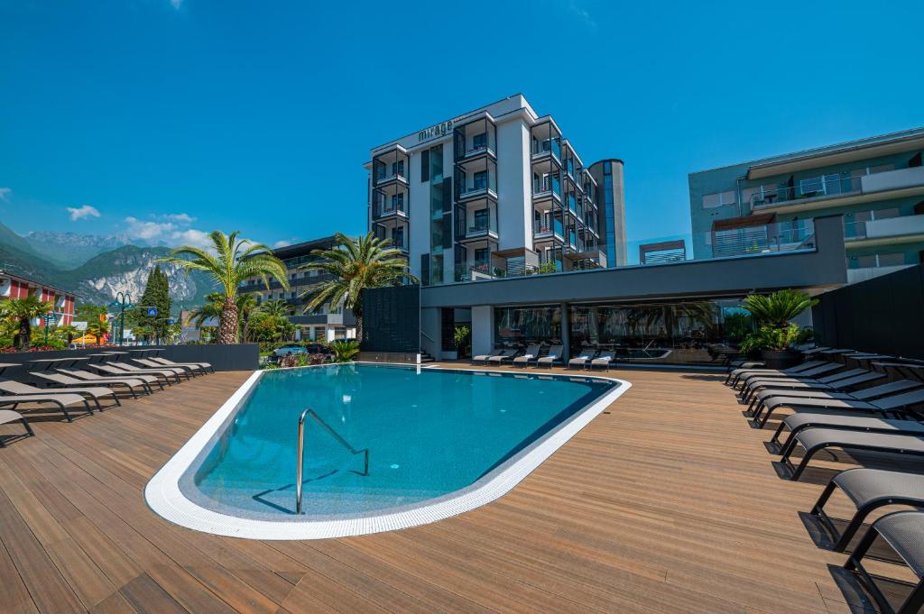 加尔达湖滨蜃景湖滨酒店的一座带椅子的游泳池以及一座建筑