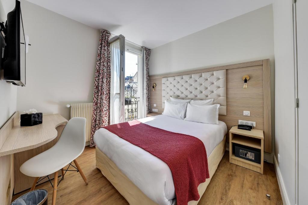 巴黎亚历山大歌剧院酒店的配有一张床、一张书桌和一扇窗户的酒店客房