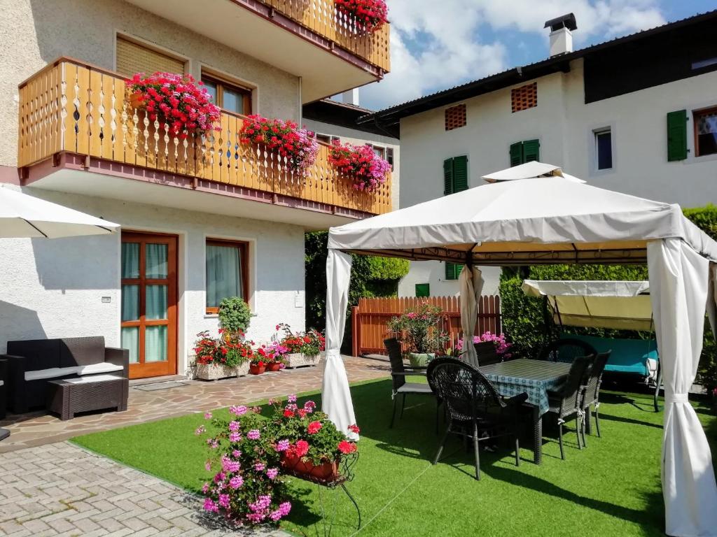科雷多Appartamento "Laghet" a piano terra con giardino的庭院配有桌椅和遮阳伞。