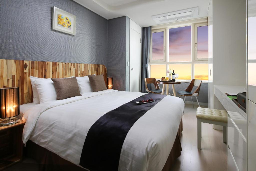 首尔爱威尔8服务公寓酒店的一间卧室配有一张大床和一张桌子
