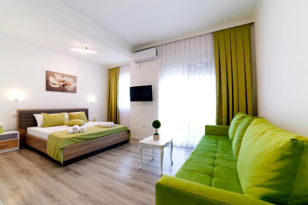 乌尔齐尼Apartments Hoxha的一间卧室配有绿色的床和沙发