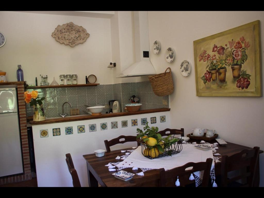 焦约萨马雷阿Villa Oceri的厨房配有一张桌子,上面放着一碗水果