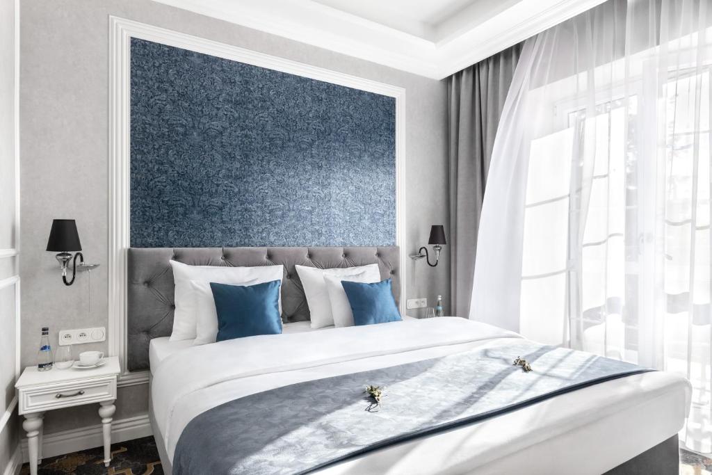 克拉科夫Merci Boutique Hotel的一间卧室设有一张蓝色墙壁的大床