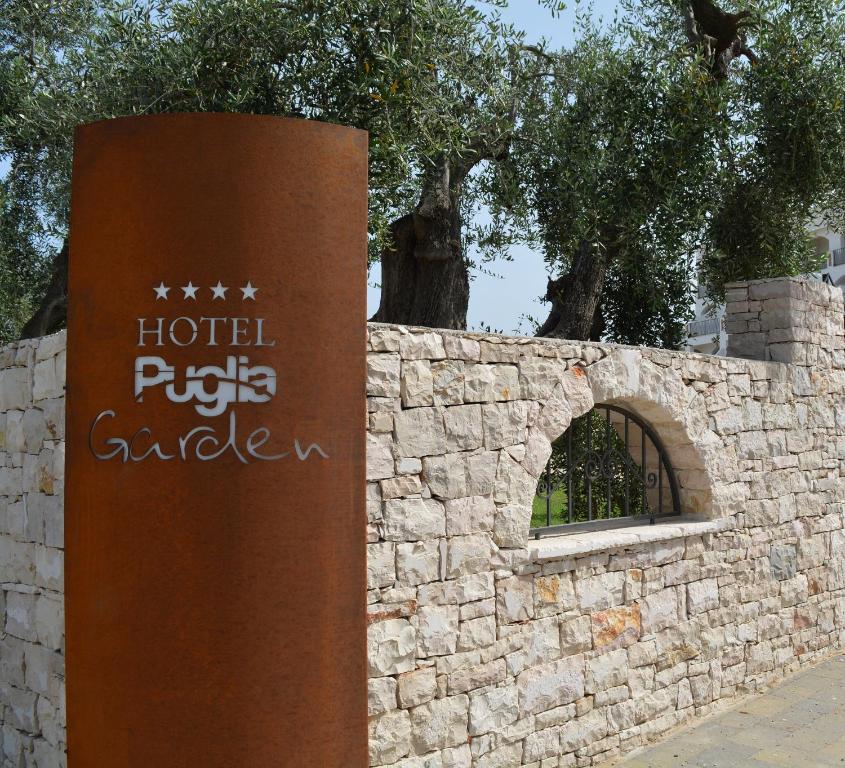 维耶斯泰Hotel Puglia Garden的石墙前的标志