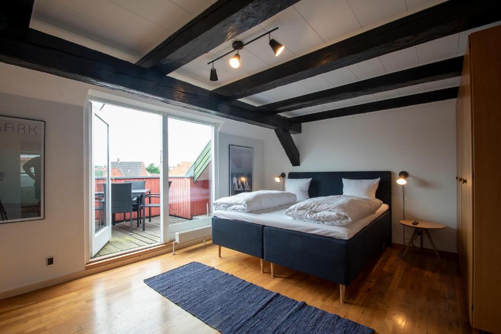 森讷堡Penthouse的一间卧室设有一张床和一个大窗户