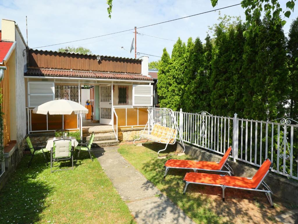 鲍洛托瑙考利Holiday Home Piccola by Interhome的一个带椅子和遮阳伞的庭院和围栏