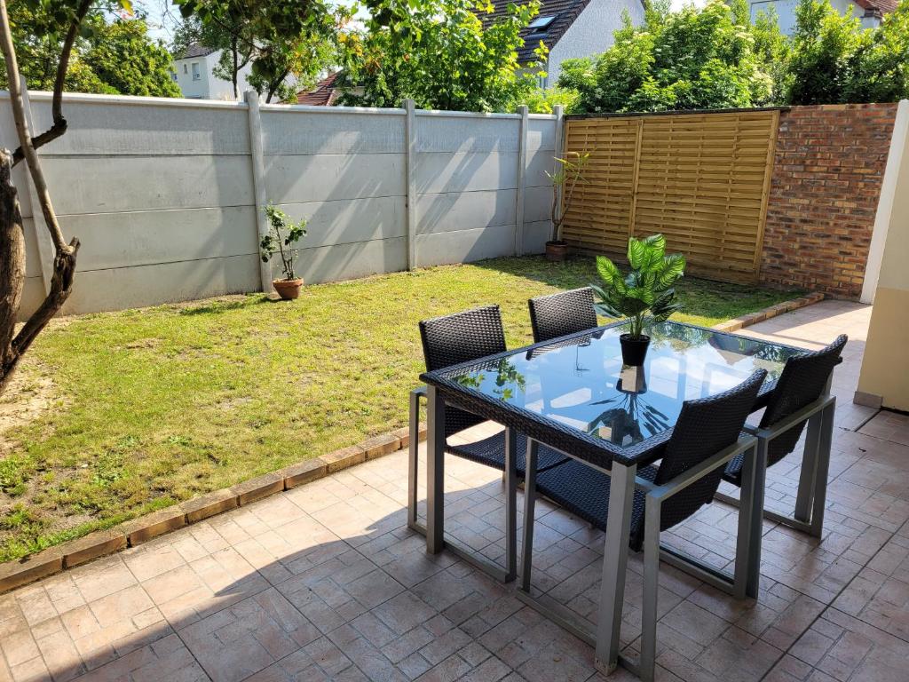 弗朗斯地区特朗布莱charmant studio de 30 m2 très calme avec sa grande belle terrasse et son jardin PRIVATIF的露台上的玻璃桌子和椅子