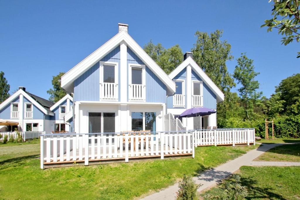 DrewoldkeFerienhaus Cumulus Haus - strandnah, Terrasse, Sauna的白色的大房子,有白色的围栏