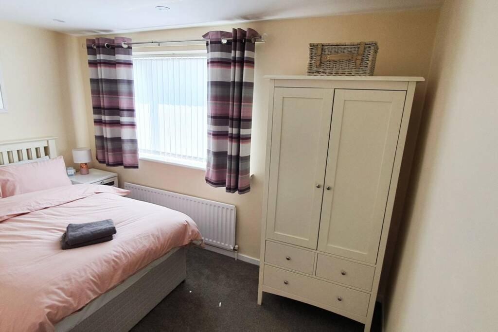 斯坦福德Stamford - Entire 1 bed cosy home.的一间卧室配有床、橱柜和窗户