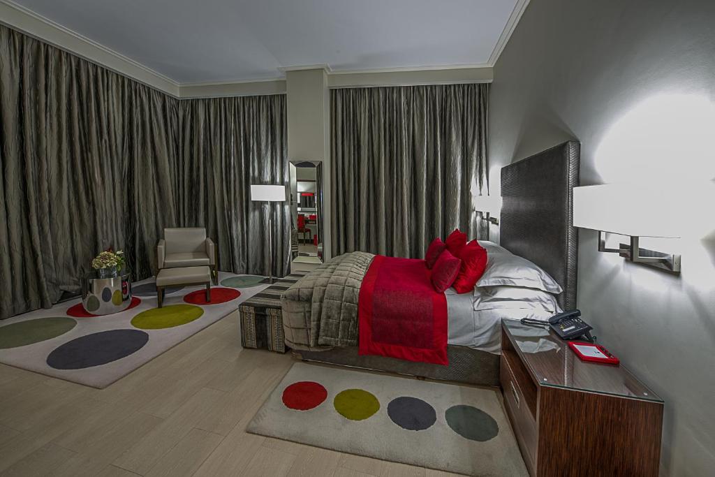 拉各斯乔治酒店的一间卧室配有一张床、一张桌子和一把椅子
