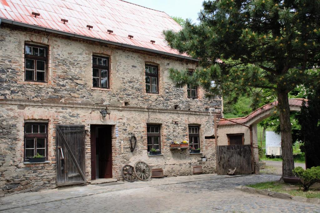 MalečovNa koňské farmě的一座红色屋顶的古老石头建筑