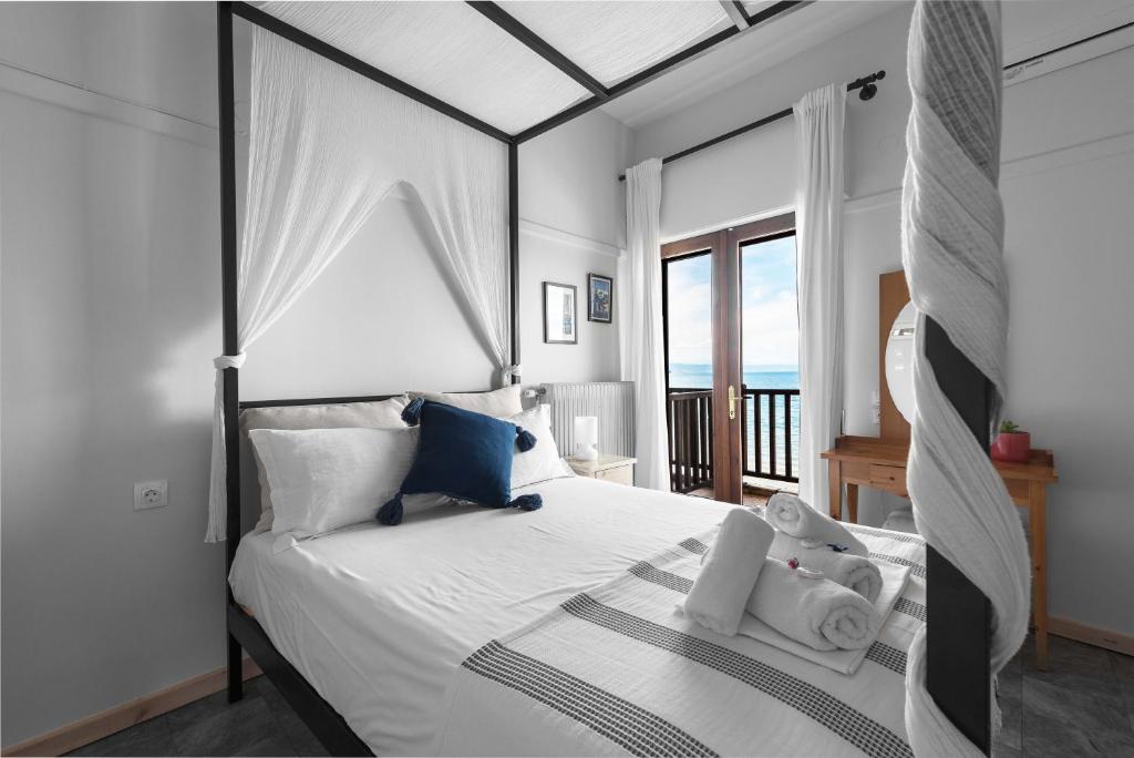 奥林匹亚达Kalokerino的卧室设有白色床,享有海景