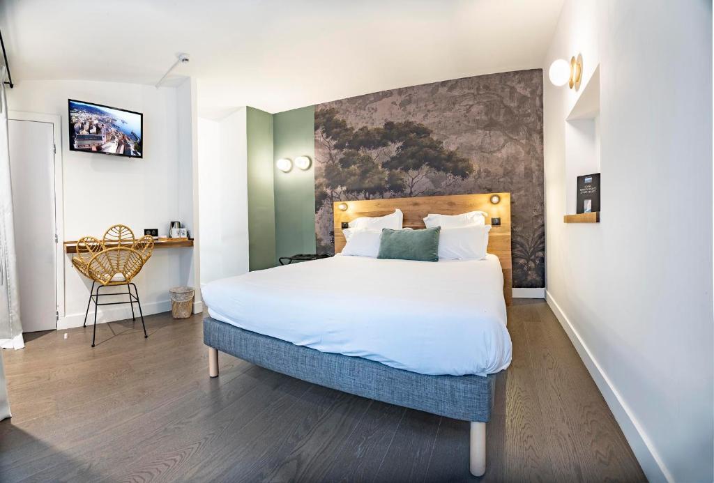 巴斯蒂亚Monsieur Miot Concept Hotel - Bastia centre的一间卧室配有一张大床和一张书桌