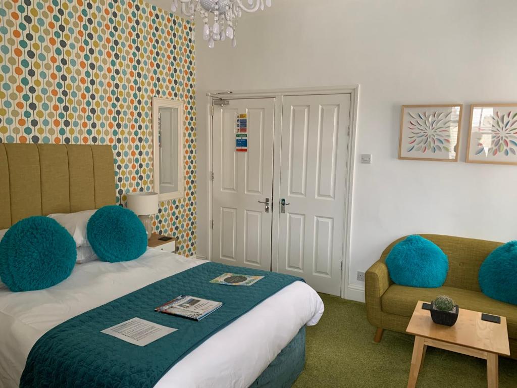 布莱克浦法尔德国际旅馆的一间卧室配有一张床、一张沙发和一把椅子