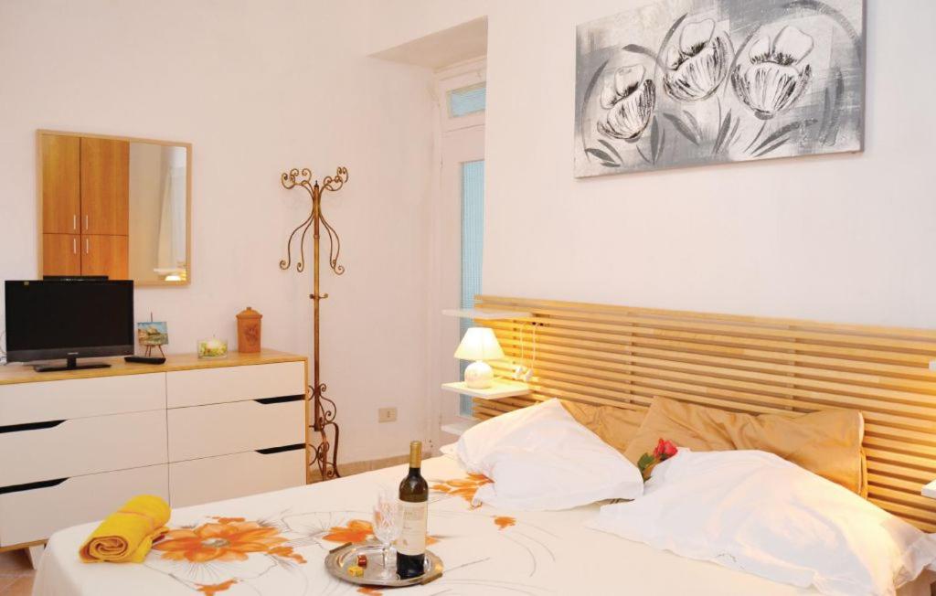 特拉罗La casetta del Marinaio的一间卧室配有一张床、一瓶葡萄酒和香蕉