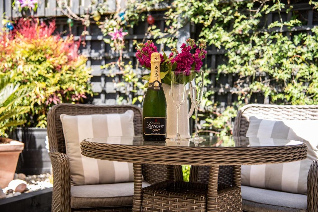 迪尔The Garden Apartment的一张桌子,上面放着一瓶葡萄酒和鲜花