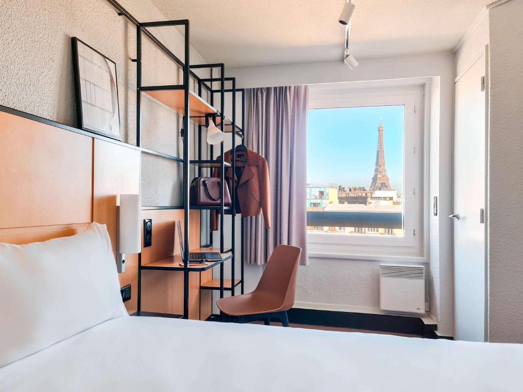 巴黎宜必思巴黎埃菲尔铁塔酒店的一间卧室配有一张床,享有艾菲尔铁塔的景色