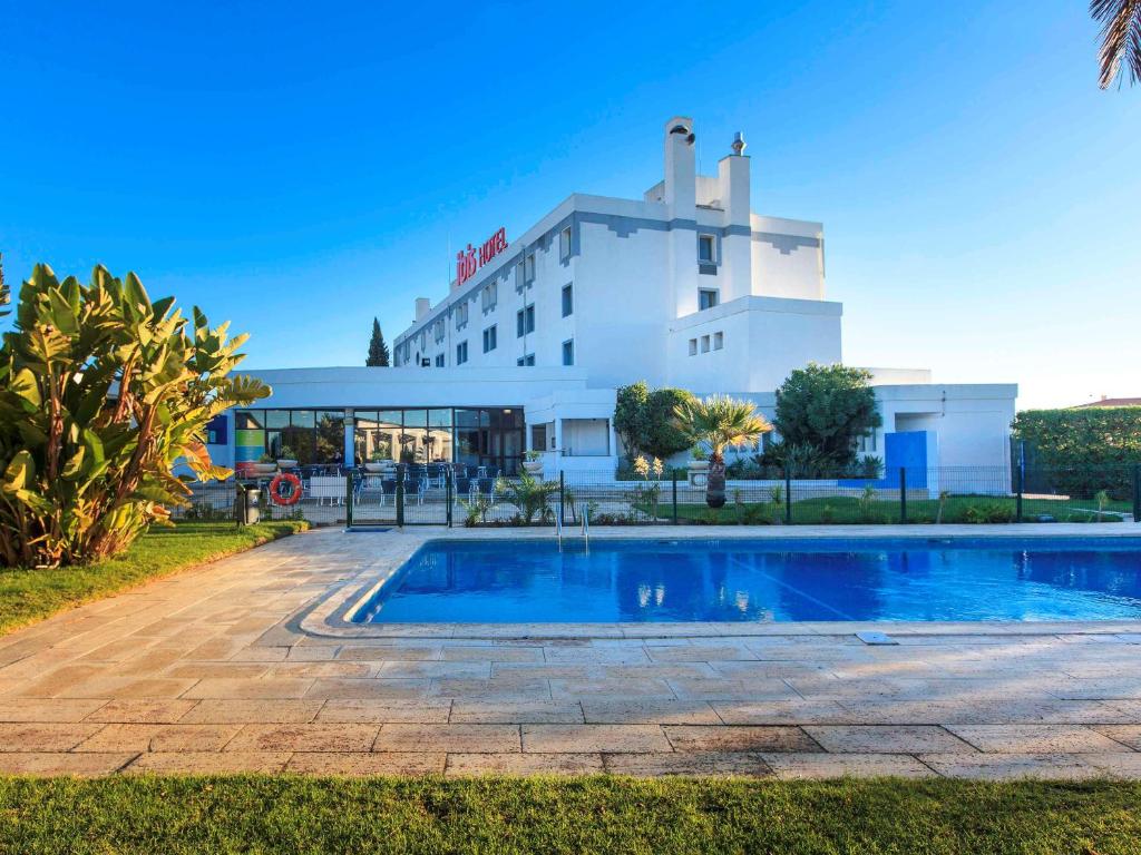 法鲁法鲁阿尔加维宜必思酒店的大楼前设有游泳池的酒店