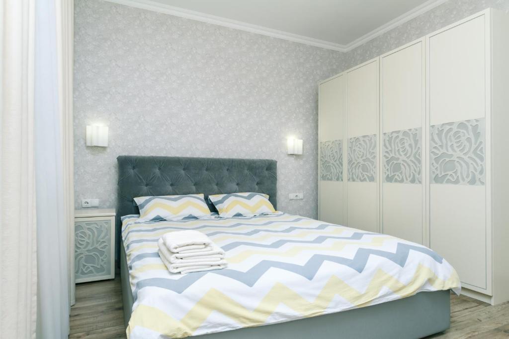 布罗瓦里Квартира VIP класса рядом с Терминалом的一间卧室配有一张带蓝色和白色棉被的床