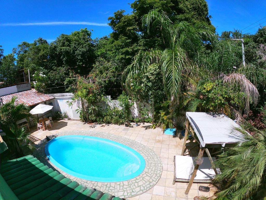 皮帕Tropical Hostel的庭院内的游泳池,配有桌椅