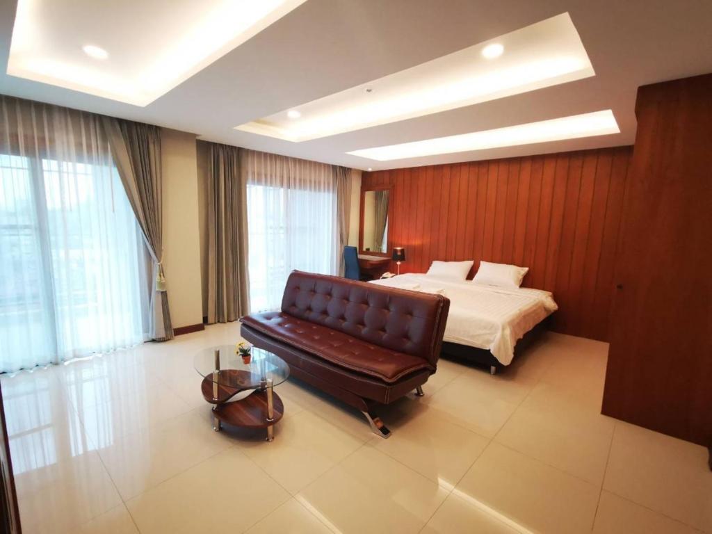清迈Private 111 square meters 2 bedrooms city ChiangMai的一间卧室配有一张床和一张皮沙发