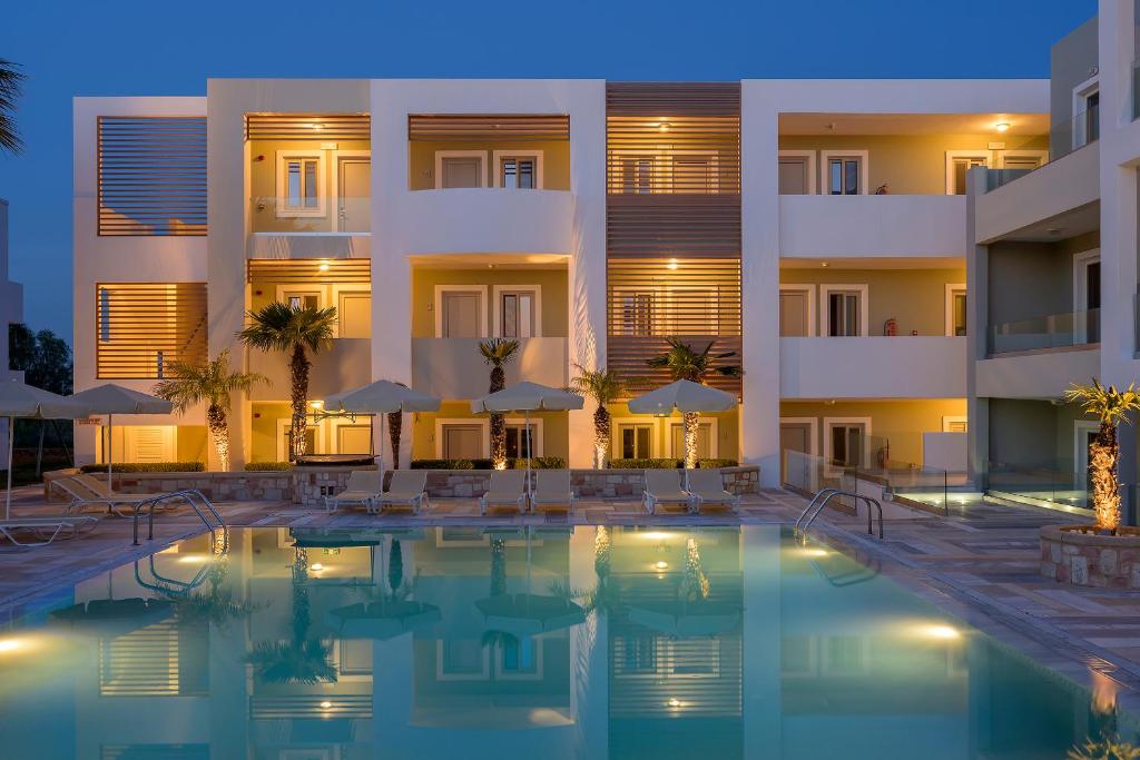 蒂加基Mythos Suites Hotel的夜间设有游泳池的酒店