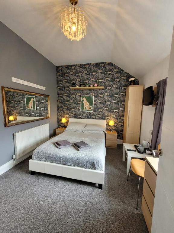 埃尔斯米尔港87号客房旅馆的卧室配有白色的床和石墙