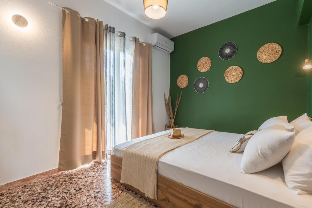 阿尔米罗斯海滩Lazaris Apartments的一间卧室设有绿色的墙壁、一张床和一个窗户