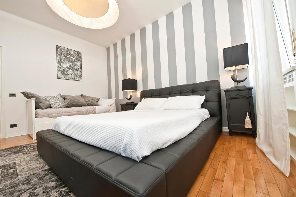 维罗纳维罗纳梅森酒店的一间卧室配有一张带黑色真皮沙发的床