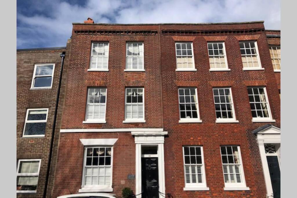 朴次茅斯Luxury 2 bed Georgian Townhouse, Old Portsmouth的大型红砖建筑,设有白色窗户