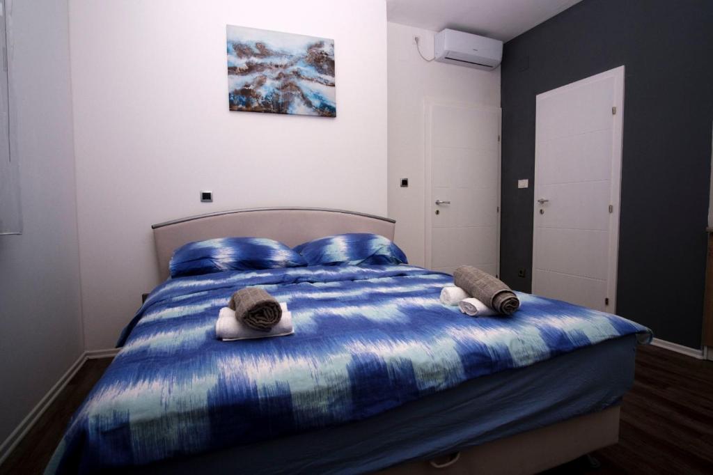 柳布什基Ana ROOMS的一间卧室配有一张蓝色的床,上面有帽子