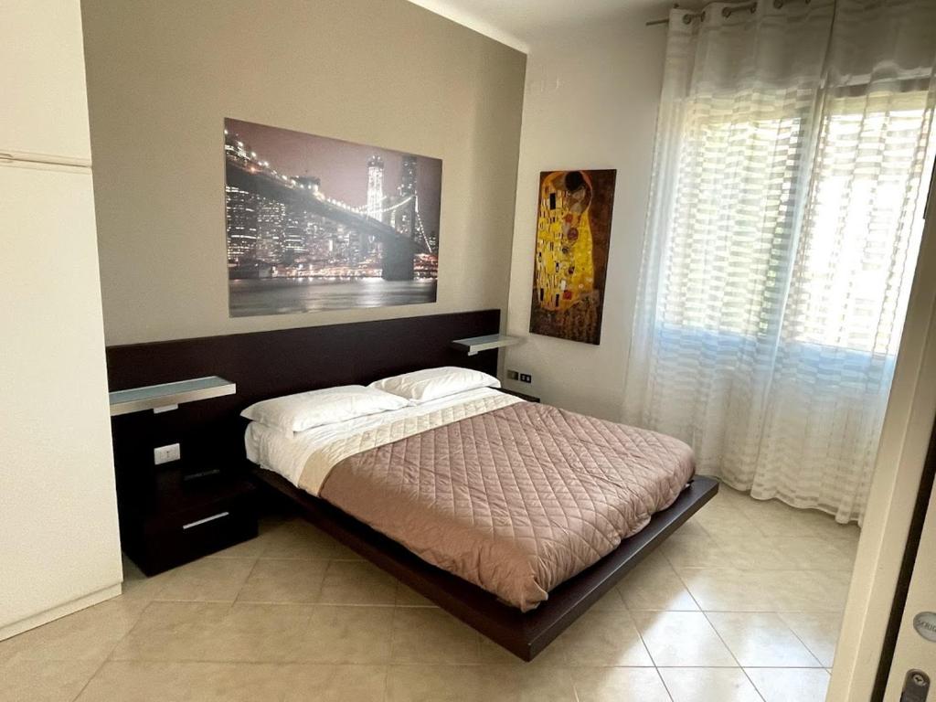 耶西Casa Rosetta Affittacamere的卧室配有一张床,墙上挂有绘画作品