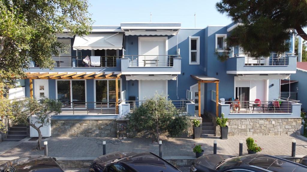 尼亚普拉莫斯Isalos Suites的一座蓝色的房子,前面有汽车停放