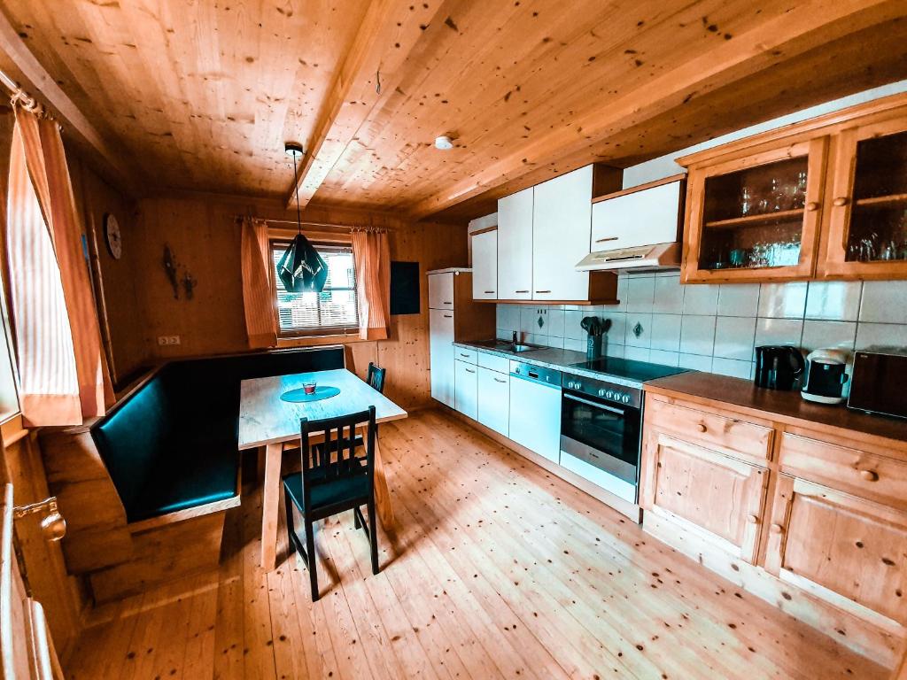 菲尔根Ferienhaus Berger的厨房铺有木地板,配有桌子。