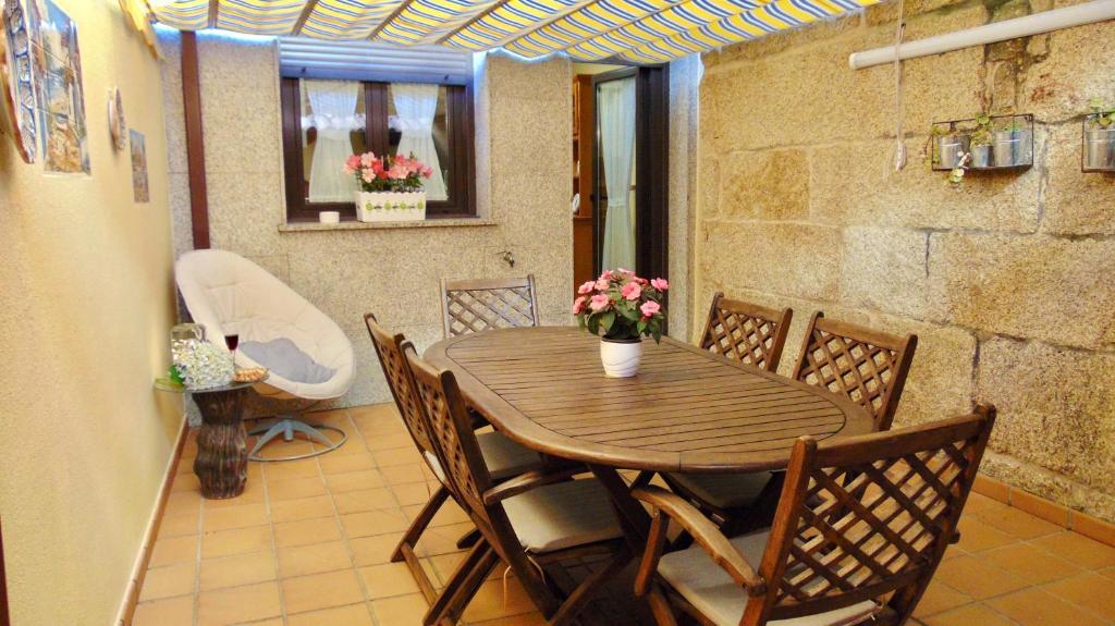 格罗韦Casa centro o grove con terraza y asador的一间带桌椅和浴缸的用餐室