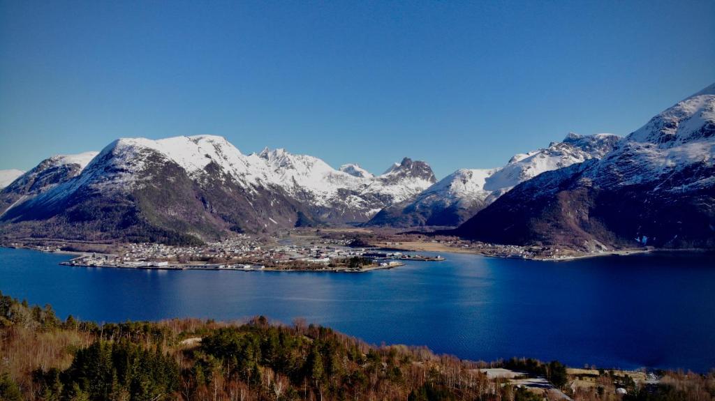 翁达尔斯内斯Åndalsnes Sentrum 1-room Apartment No3的湖中的一个小镇,有积雪覆盖的山脉