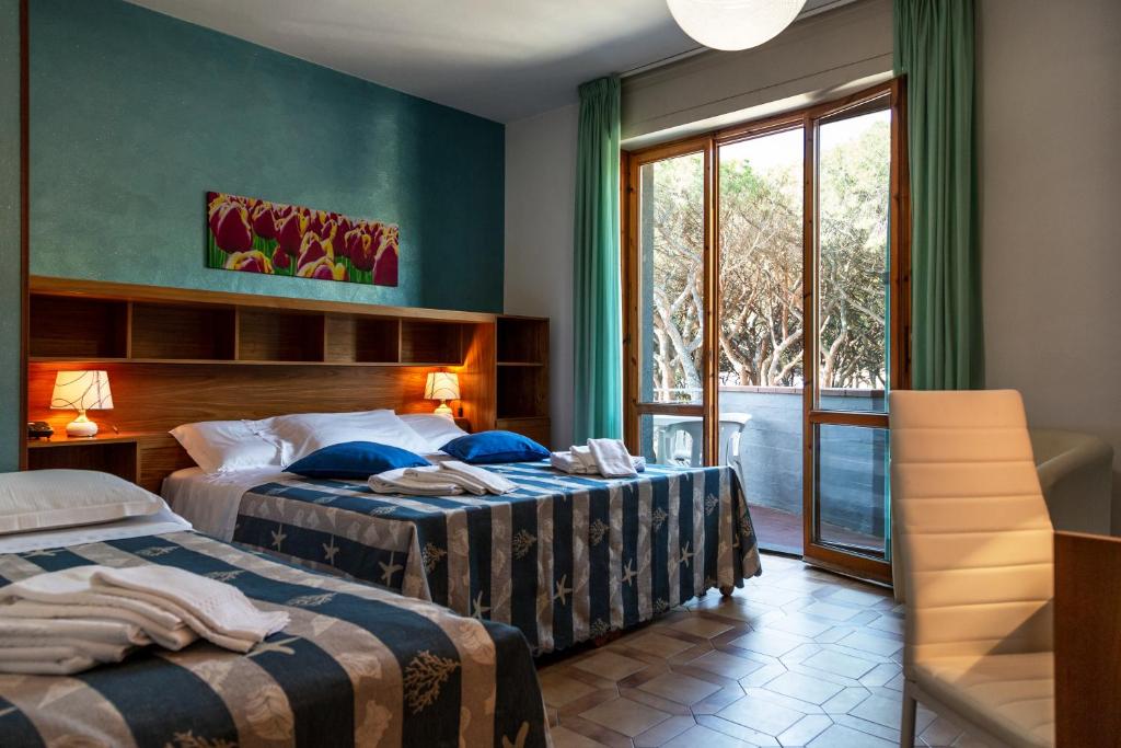 福洛尼卡Hotel Parco dei Pini的酒店客房设有两张床和窗户。